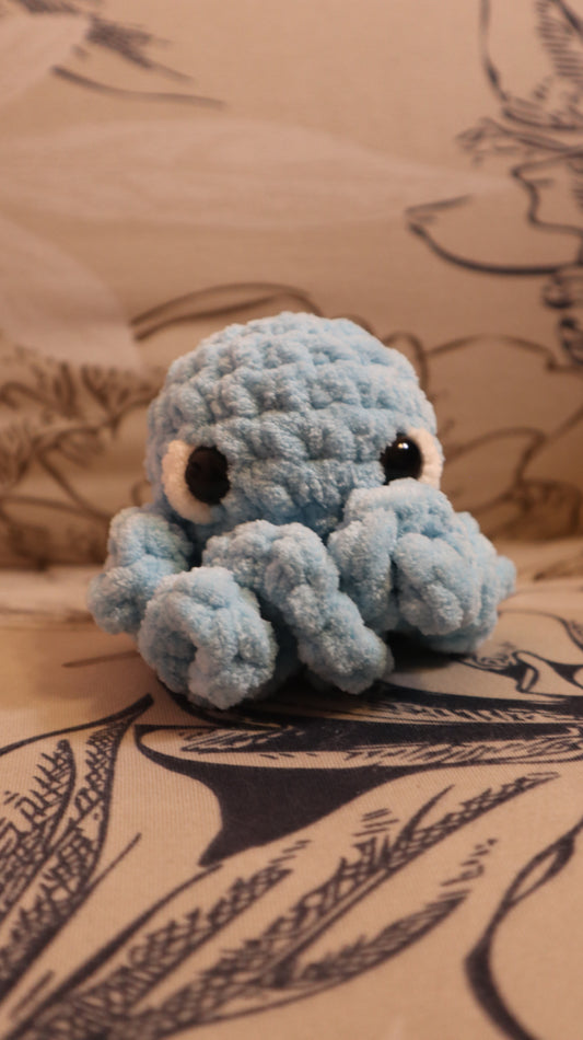 Light Blue Crocheted Octopus plushie on a floral fabric background
